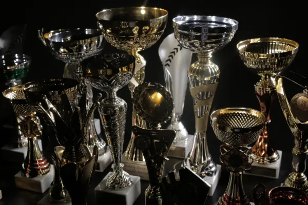 A collection of gold and silver competition trophies displayed together against a dark background.