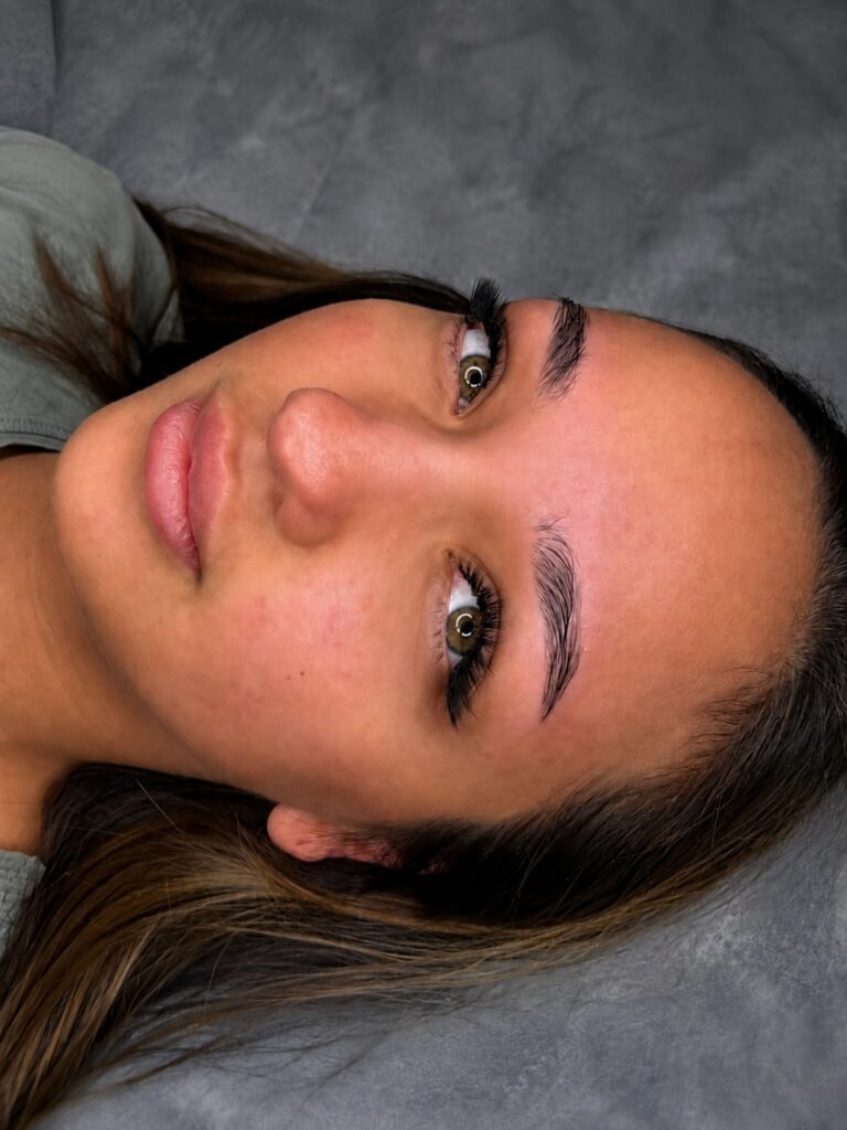 Close-up of a woman showing lifted lashes and neatly shaped, brushed-up brows