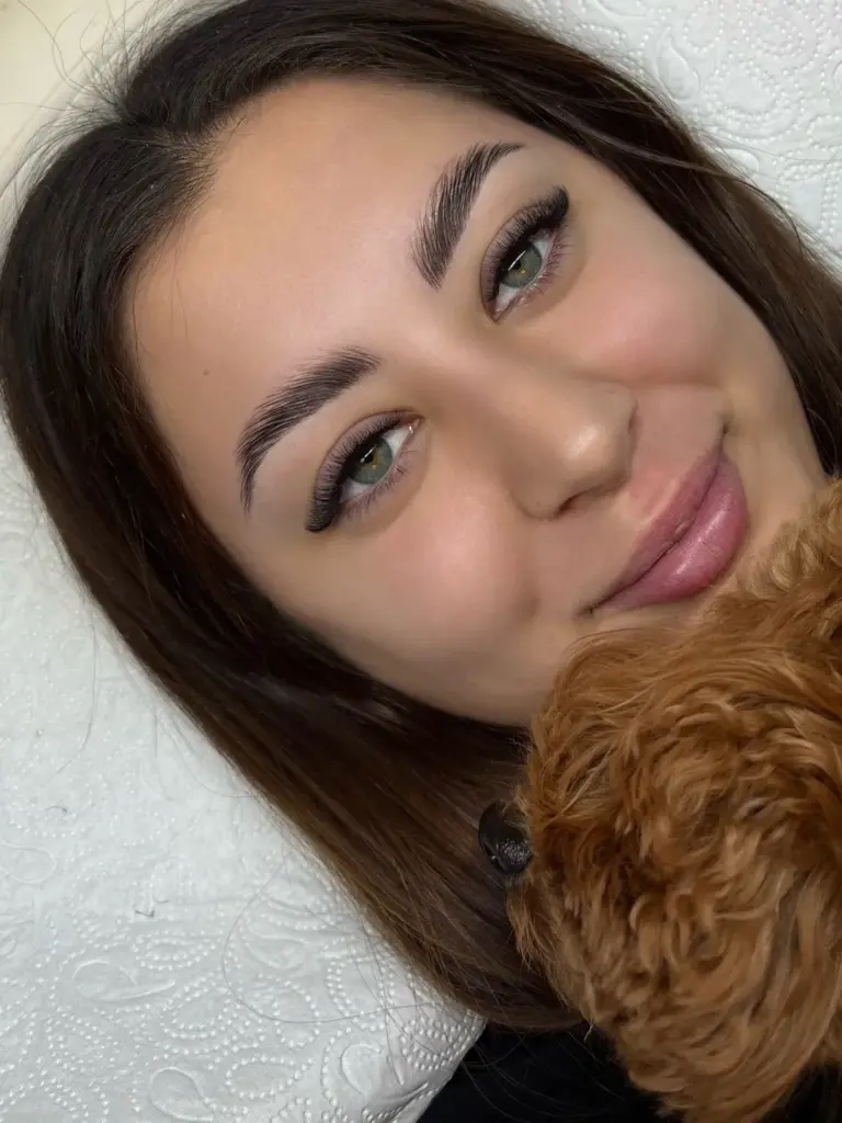 Close-up portrait showcasing long lash extensions and neatly shaped, feathered eyebrows.