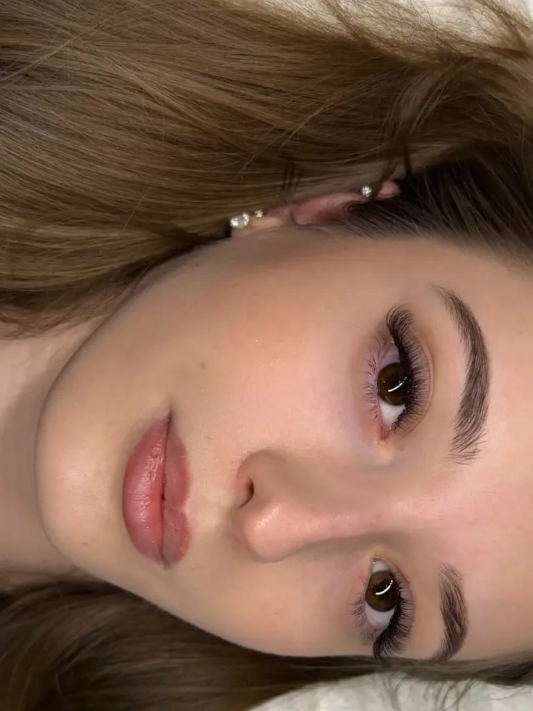 Close-up of a woman with long, voluminous eyelash extensions and neatly shaped brows.